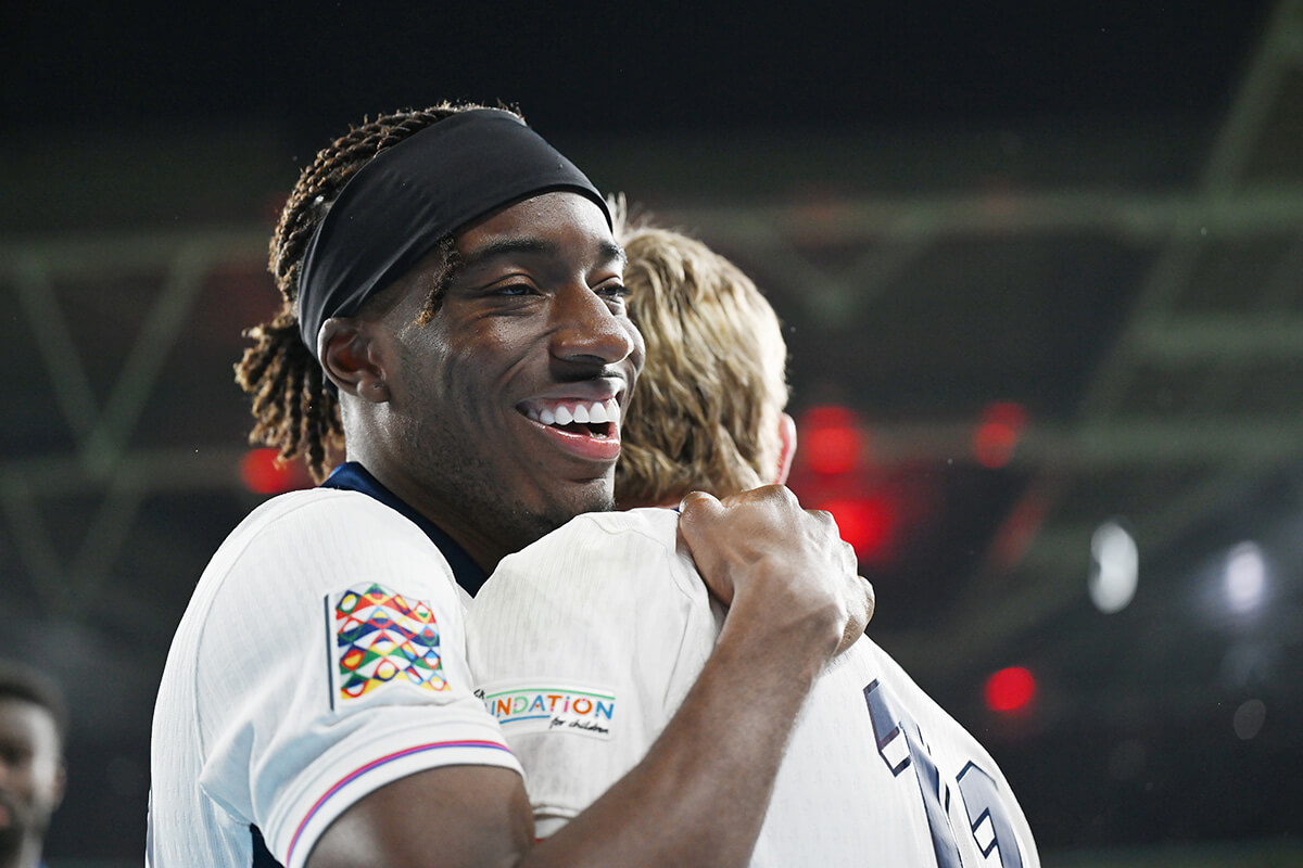 Image showing an England player celebrating in a hug with the UEFA Nations League badge on his arm