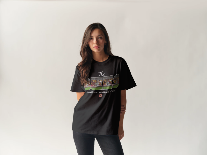 Image showing a female model wearing a Brentford t shirt which reads 'The Bees' and features an illusration of the stadium inside the words