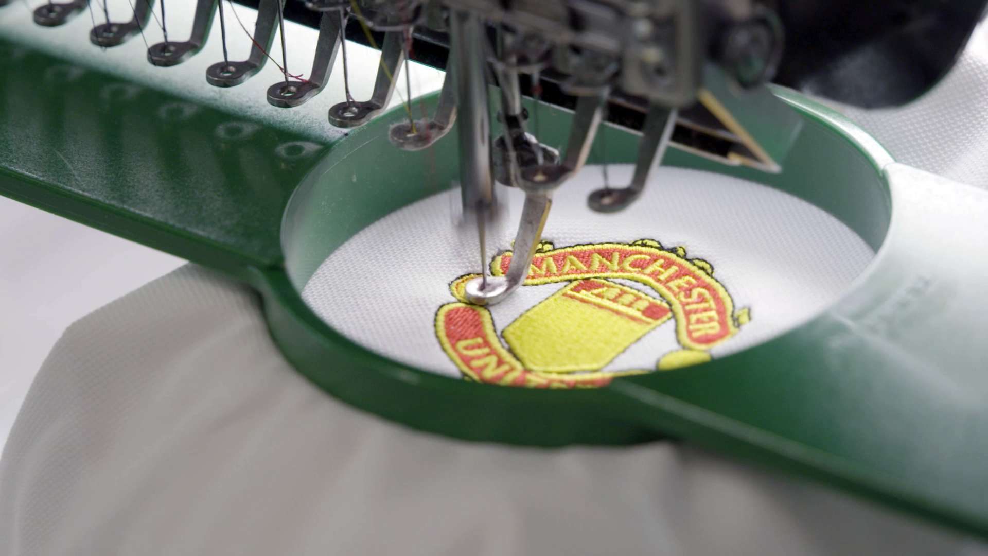 Image showing the Manchester United Crest being embroidered onto a jersey by ID UNLIMITED